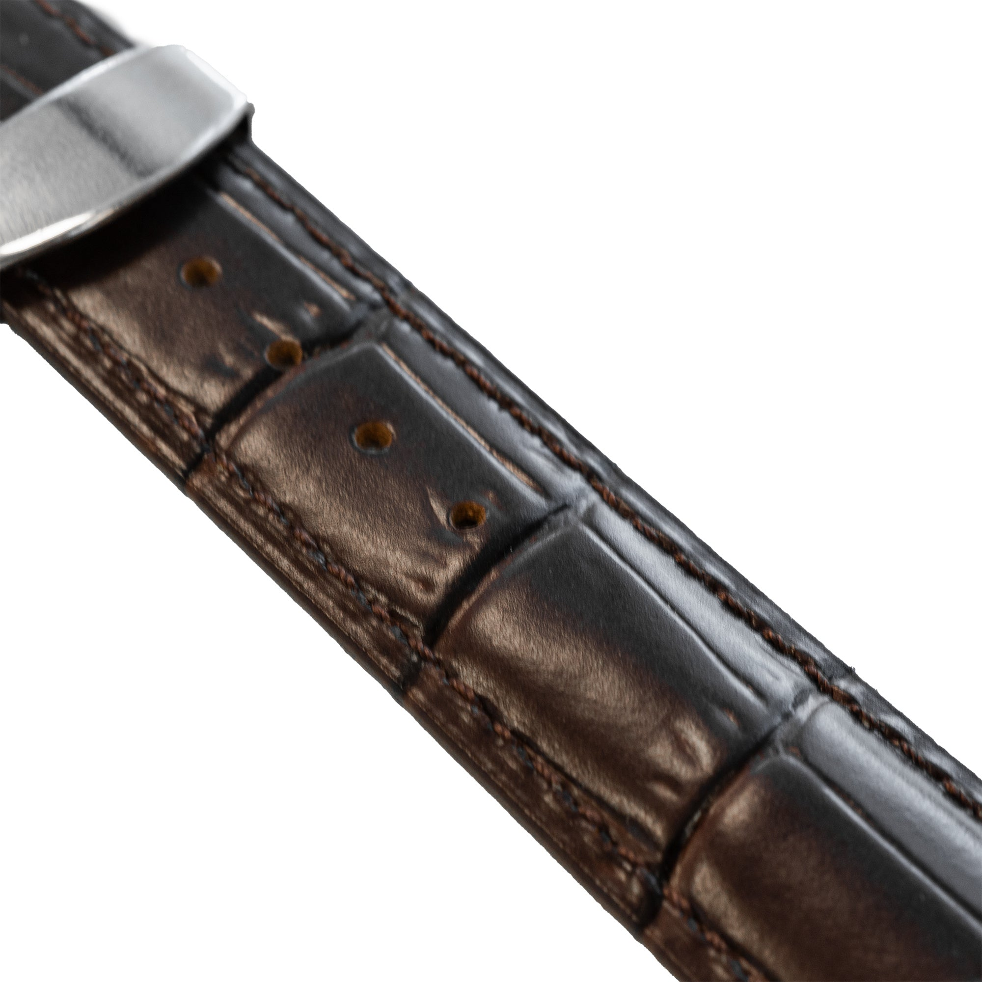 Nahaufnahme eines braunen Lederarmbands mit silberner Schnalle. Das Band hat ein strukturiertes Muster und sichtbare Nähte.
