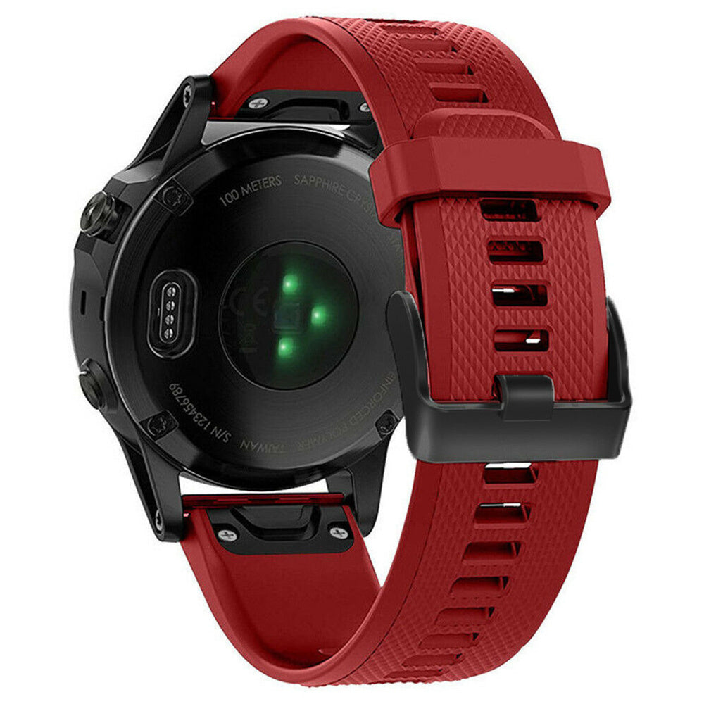 Eine schwarze Smartwatch mit rotem Armband wird von hinten gezeigt. Die Uhr hat grüne Sensoren. Das Armband ist strukturiert und mit einem schwarzen Verschluss gesichert.