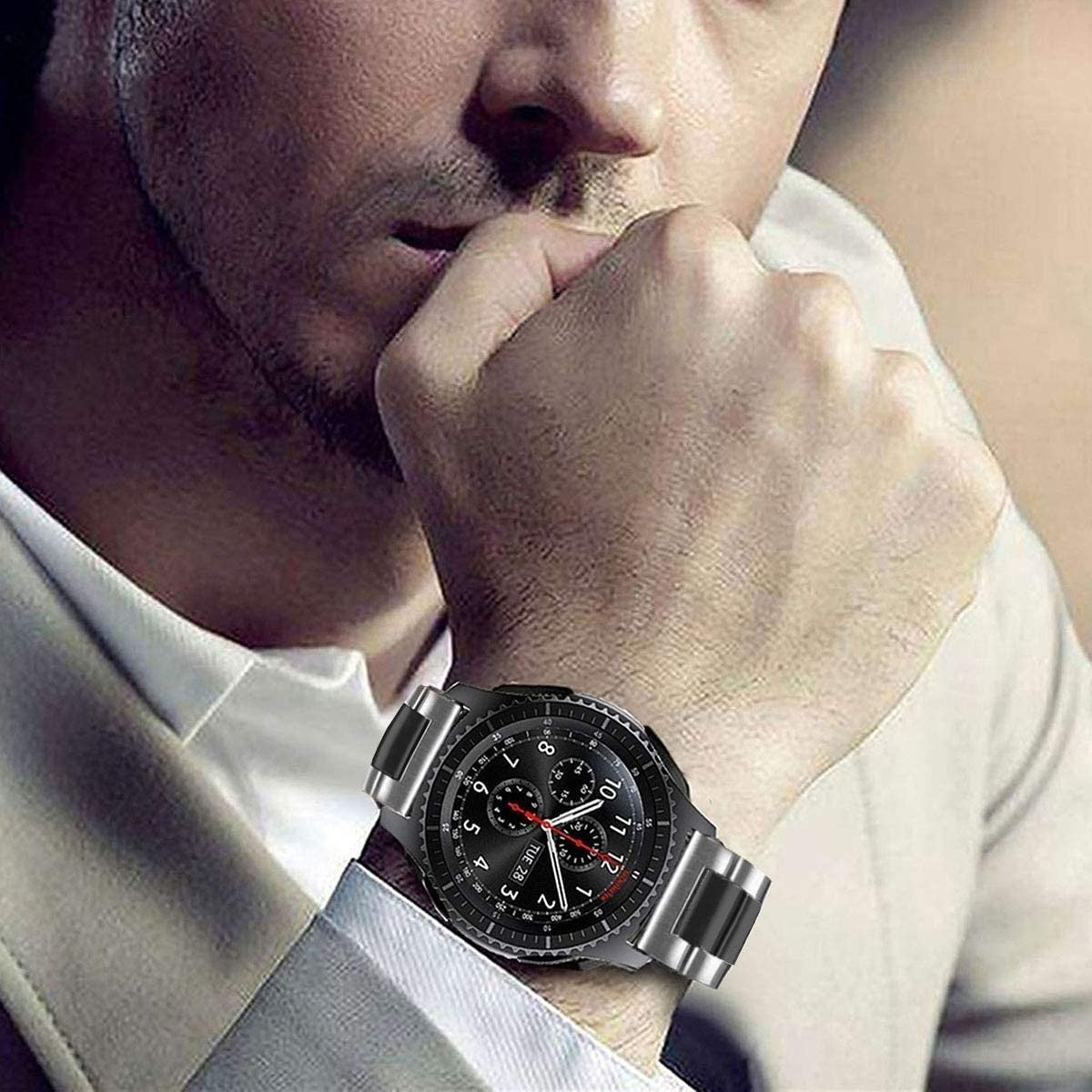 Ein Mann, der eine Uhr mit schwarzem Zifferblatt trägt. Er beißt sich in den Fingernagel. Die Uhr hat ein silbernes Armband.