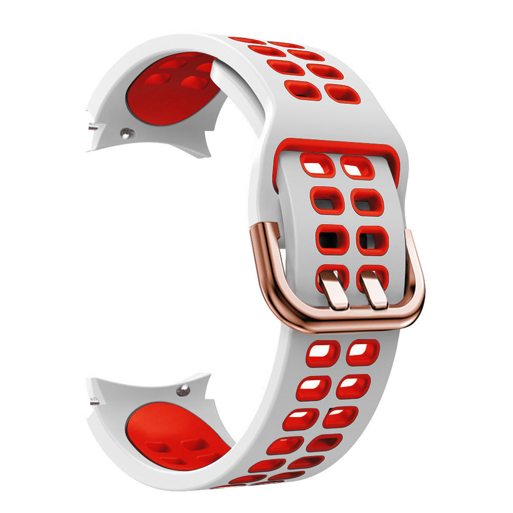 Weißes und rotes Uhrenarmband mit perforierten Löchern, bronzefarbene Schnalle. Das Armband ist gebogen und zeigt die rote Innenseite.