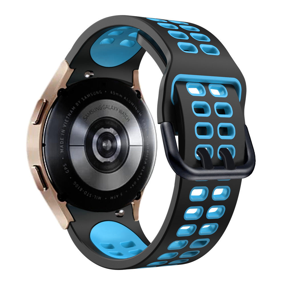 Eine Samsung Galaxy Watch mit einem schwarz-blauen Armband. Die Uhr hat eine goldene Lünette und einen schwarzen Rücken. Das Armband ist perforiert.