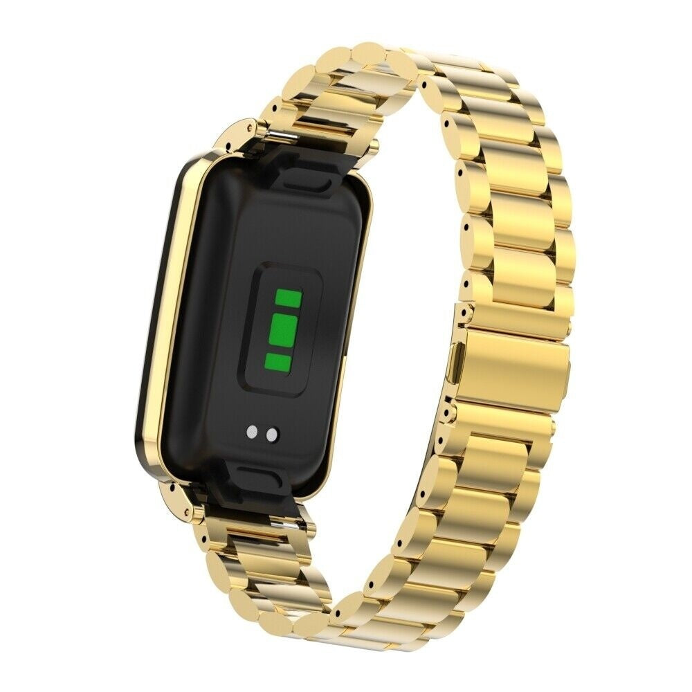 Eine goldene Smartwatch mit schwarzem Bildschirm, der grüne Anzeigen zeigt, und einem goldfarbenen Kettenglied-Armband auf weißem Hintergrund.
