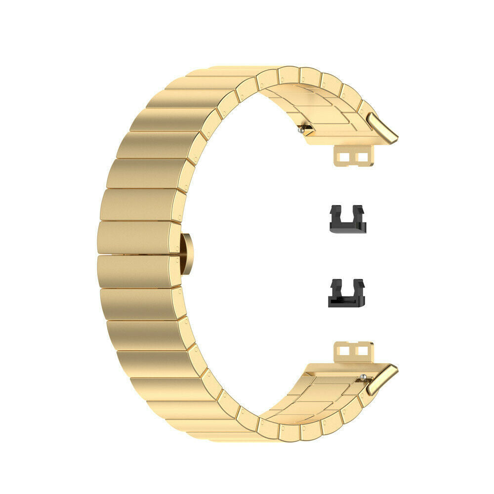 Ein goldenes Uhrenarmband ist gebogen und hat rechteckige Glieder. Darunter zwei schwarze Verschlüsse.