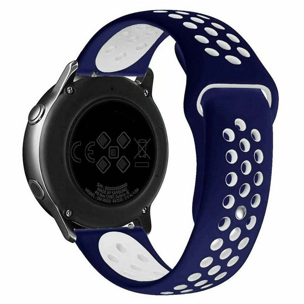 Eine Smartwatch mit marineblauem und weißem Armband wird gezeigt. Die Uhr ist silberfarben mit schwarzer Rückseite. Das Armband hat Löcher.
