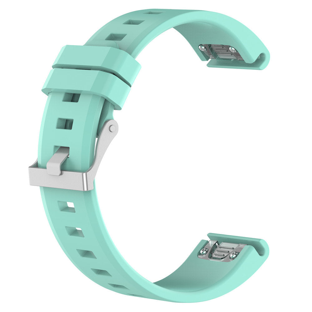 Ein helltürkisfarbenes Uhrenarmband mit silberner Schnalle wird vor weißem Hintergrund gezeigt. Das Band hat ein gebogenes Design mit quadratischen Aussparungen.