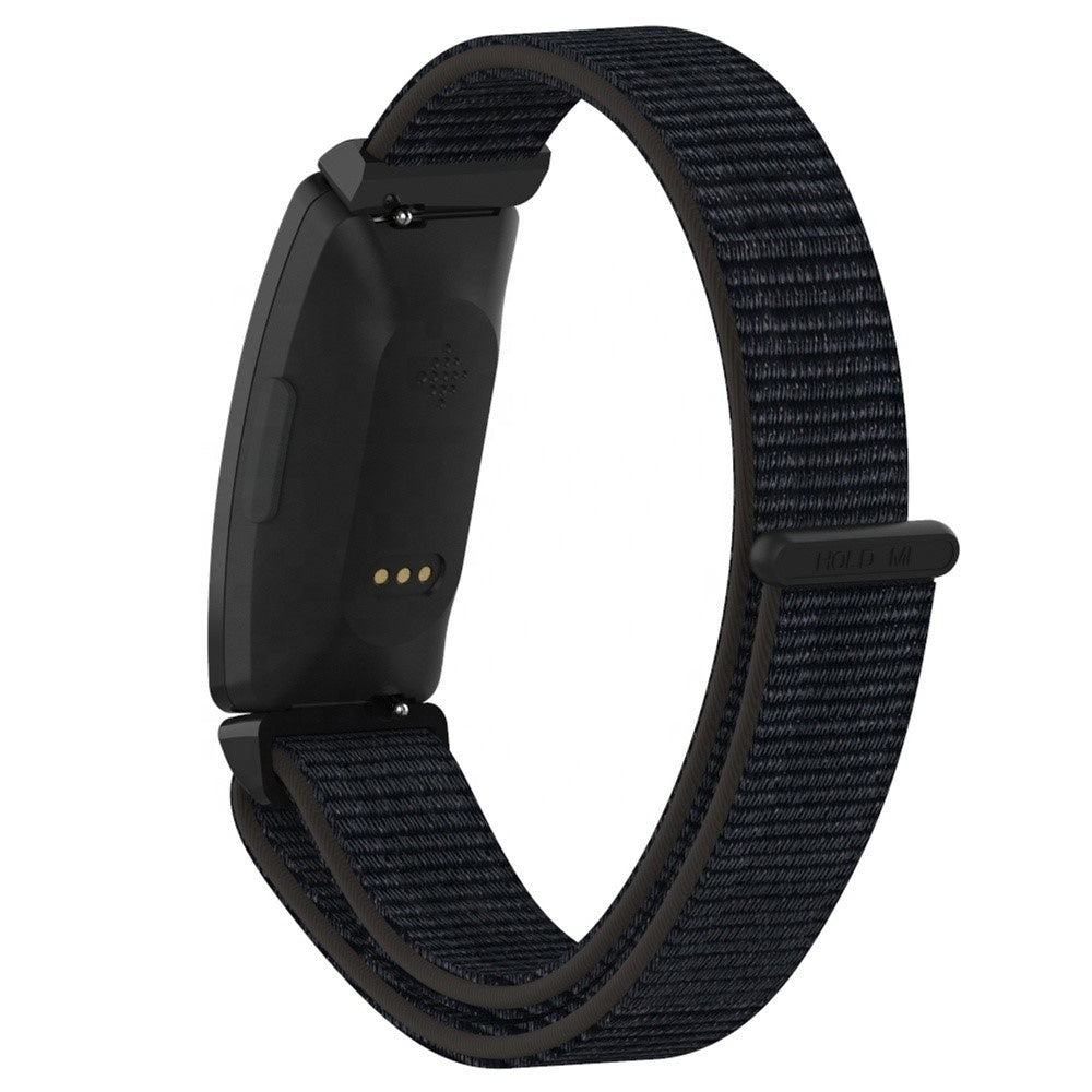 Ein schwarzer Fitnesstracker mit einem dunkelblauen Stoffarmband. Die Rückseite hat eine Ladeanschluss und einen Herzfrequenzsensor.