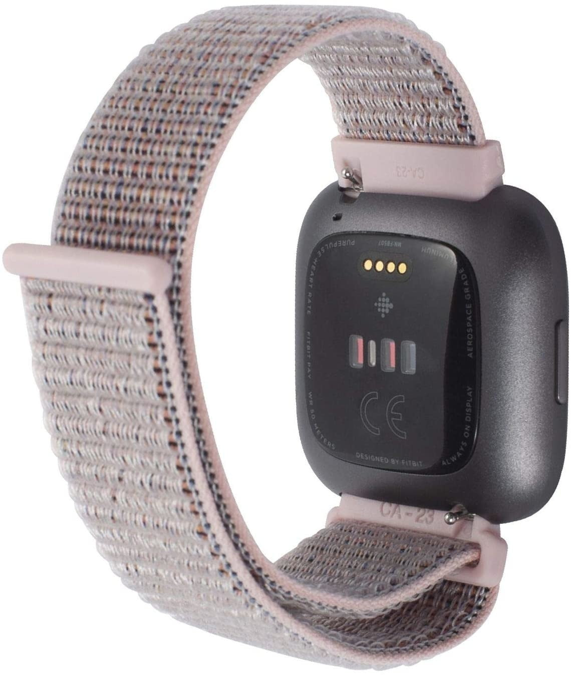 Eine graue Fitbit-Smartwatch mit einem gewebten rosa-beige Band ist abgebildet. Das Zifferblatt zeigt Details, und das Band ist verbunden.