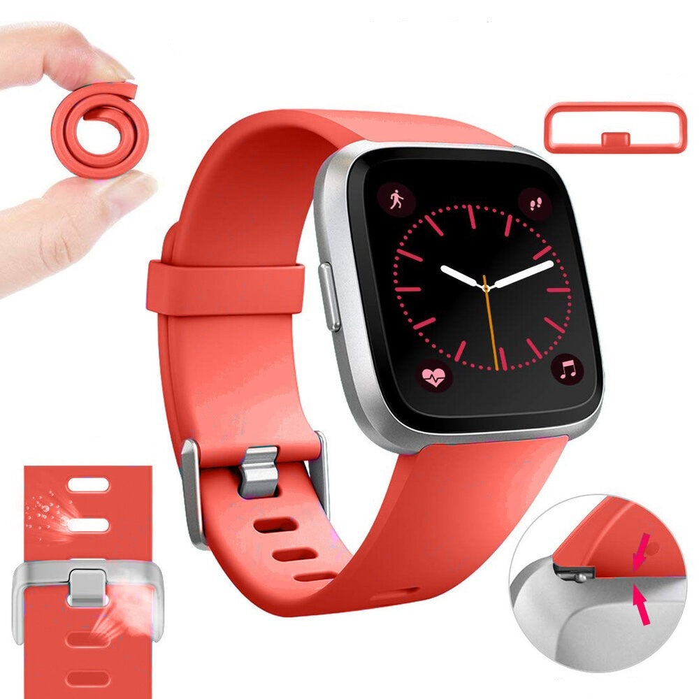 Eine rote Smartwatch mit schwarzem Bildschirm, der die Uhrzeit anzeigt. Teile des Armbands sind abgenommen. Eine Hand hält ein gerolltes Armband.