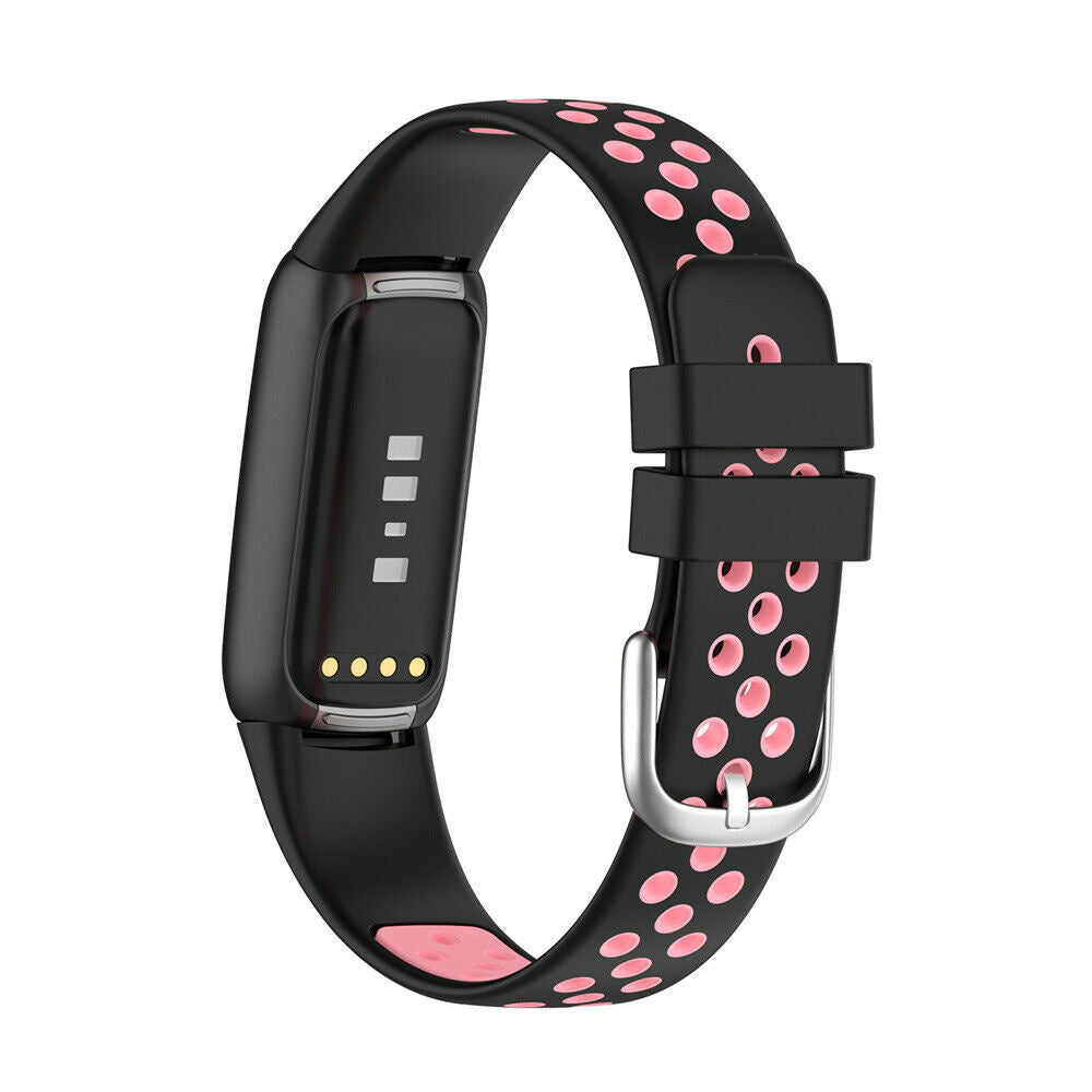 Schwarzer Fitnesstracker mit rosa gepunktetem Band. Es hat eine silberne Schnalle. Der Tracker zeigt vier Punkte und drei Linien.