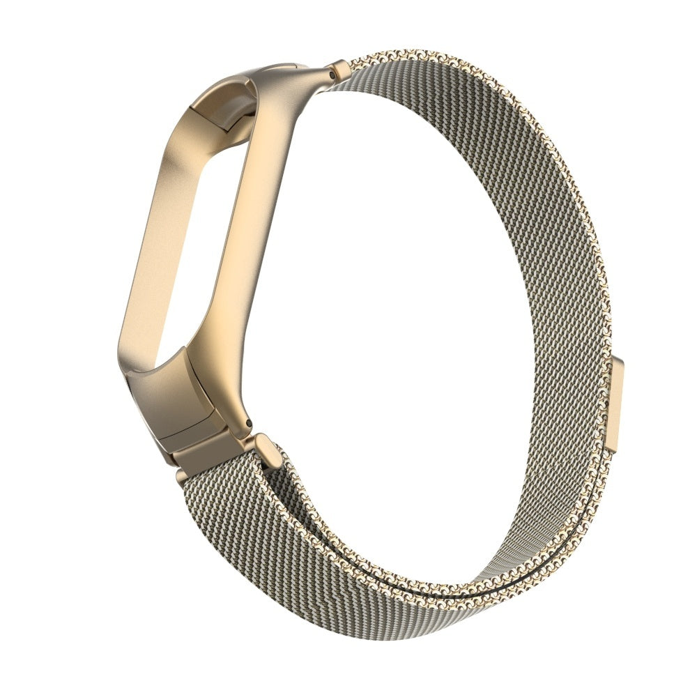 Ein goldfarbenes Armband liegt auf weißem Grund. Es hat einen Magnetverschluss und ein Mesh-Design und erscheint gebogen.