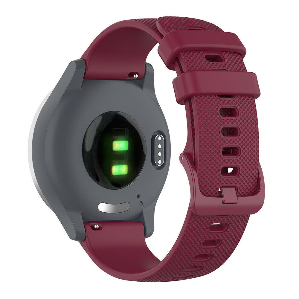 Eine Smartwatch mit maroonfarbenem Armband ist abgebildet. Das Zifferblatt ist grau mit Sensoren und grünen Lichtern, das Armband ist strukturiert.