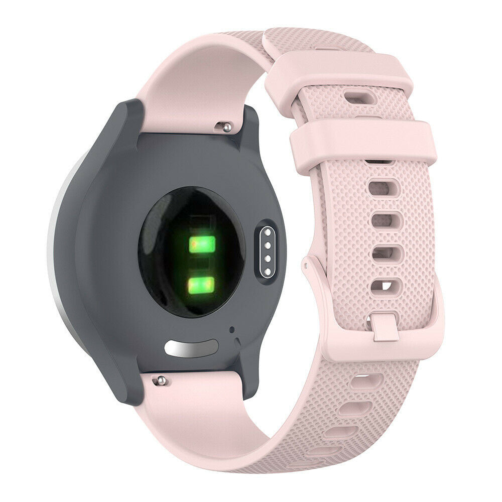 Unterseite einer Smartwatch, grau mit grünem Sensor. Rosa Armband befestigt. Fokus auf Rückseite, Sensoren und Armbanddetails.