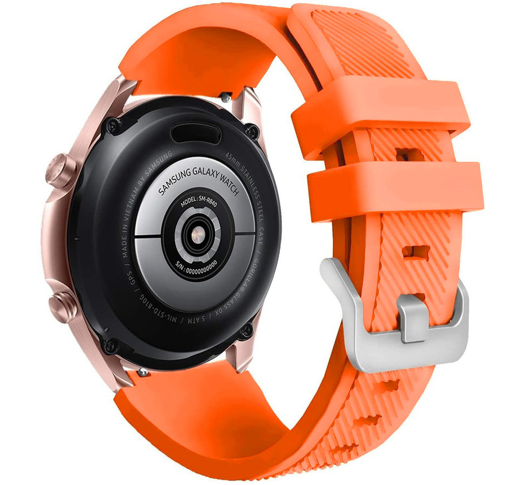 Eine Samsung Galaxy Watch mit orangefarbenem Armband und roségoldenem Gehäuse. Auf der Rückseite der Uhr sind Details zu Modell und Seriennummer zu sehen.
