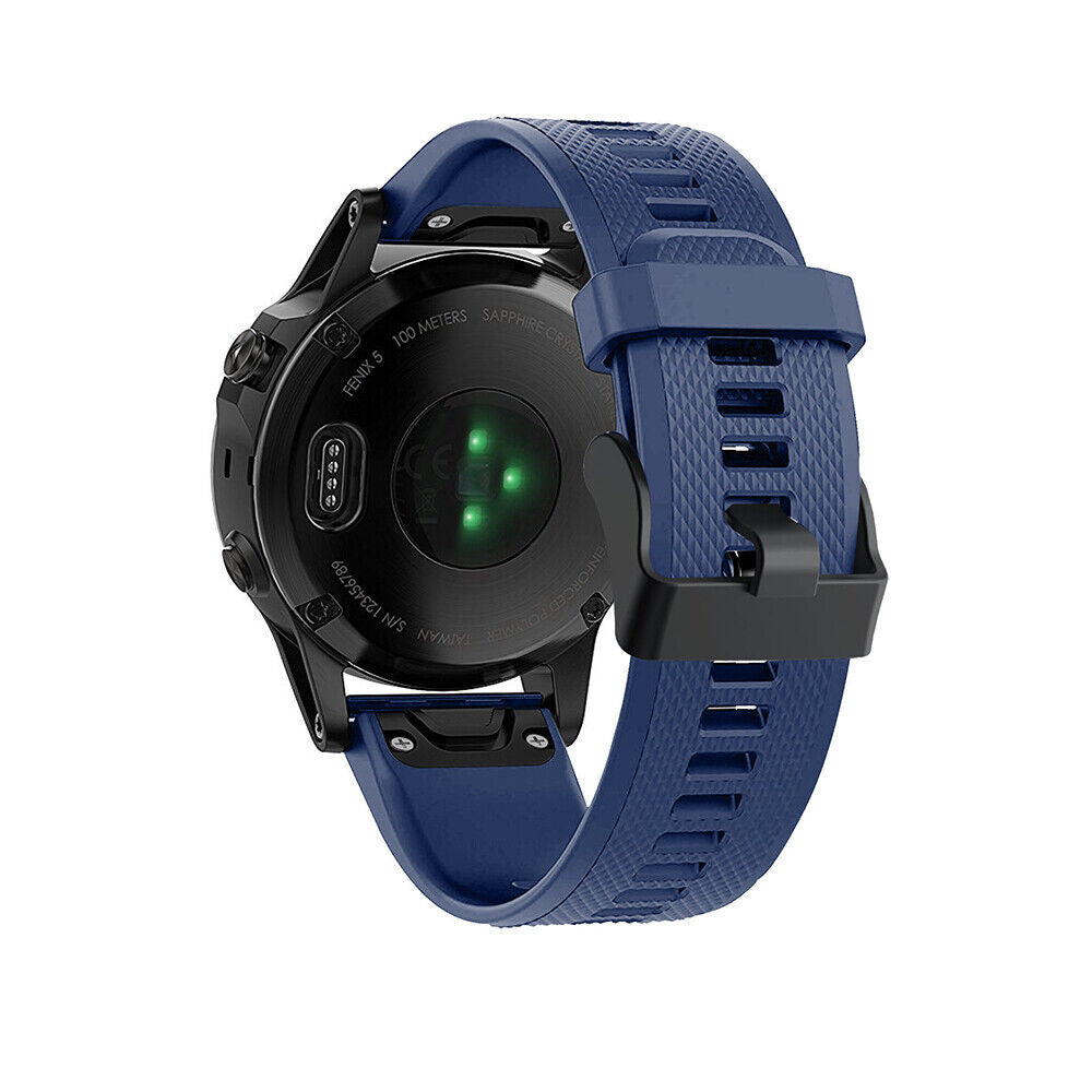 Eine schwarze Garmin Fenix 5 Uhr mit blauem Armband. Die Rückseite zeigt Sensoren und Text. Das Armband ist geschnallt und hat ein Muster.