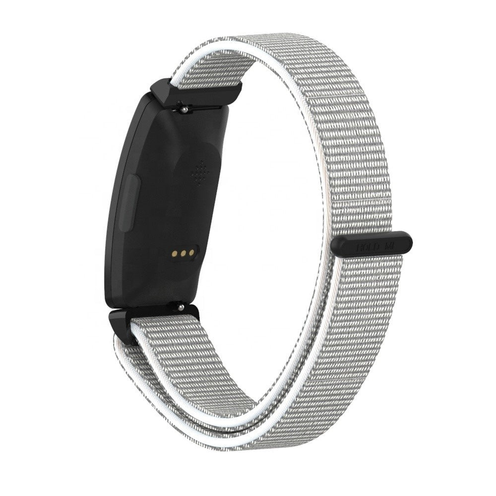 Ein schwarzer Fitnesstracker mit hellgrauem Stoffband. Das Band ist umgeschlungen und zeigt die Innen- und Außenseite.