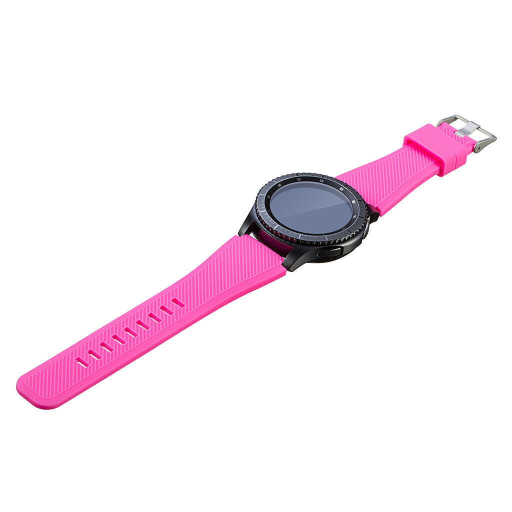 Eine schwarze Smartwatch mit pinkfarbenem Armband liegt auf einer weißen Oberfläche. Das Armband ist mit einer Schnalle am Zifferblatt befestigt.