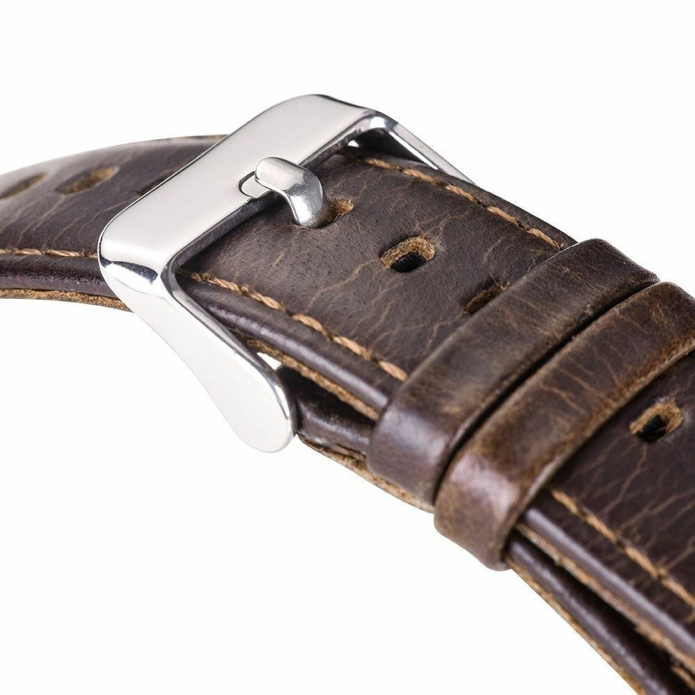 Nahaufnahme eines braunen Leder-Uhrenarmbands mit silberner Schnalle. Nähte und Abnutzung sind sichtbar.