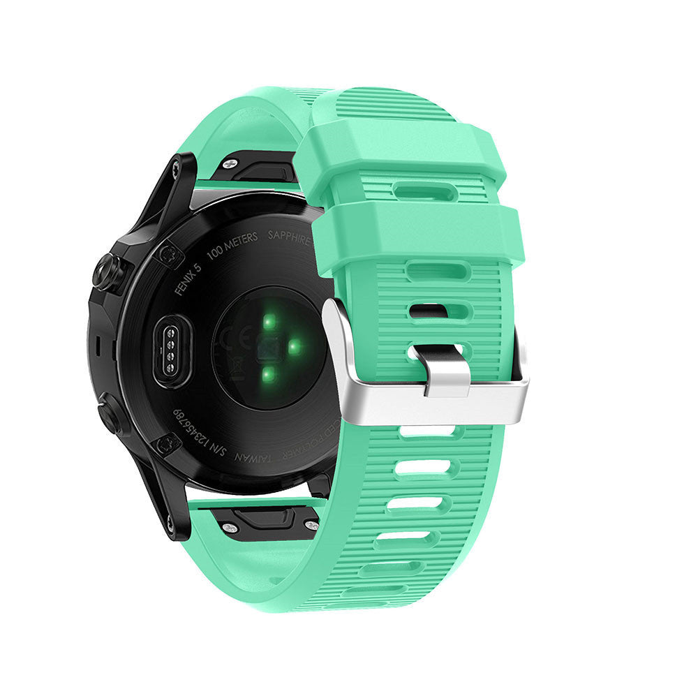 Eine schwarze Garmin-Uhr mit mintgrünem Armband wird gezeigt. Das Zifferblatt ist sichtbar, zusammen mit dem Armband und der Schließe.