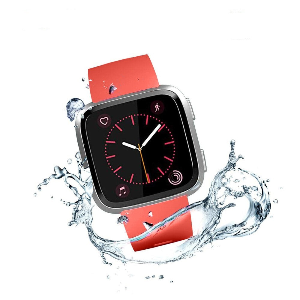 Eine Smartwatch mit rotem Armband ist von Wasserspritzern umgeben. Das Zifferblatt zeigt Symbole und Uhrzeit. Silbernes Gehäuse.