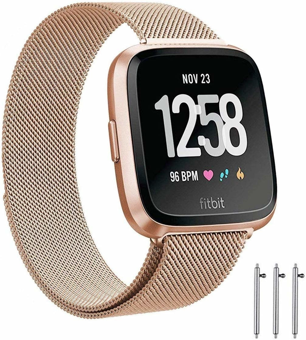 Eine roségoldene Fitbit-Uhr zeigt am 23. November 12:58 Uhr an, mit 96 BPM. Sie hat ein Mesh-Band und drei silberne Stifte unten.