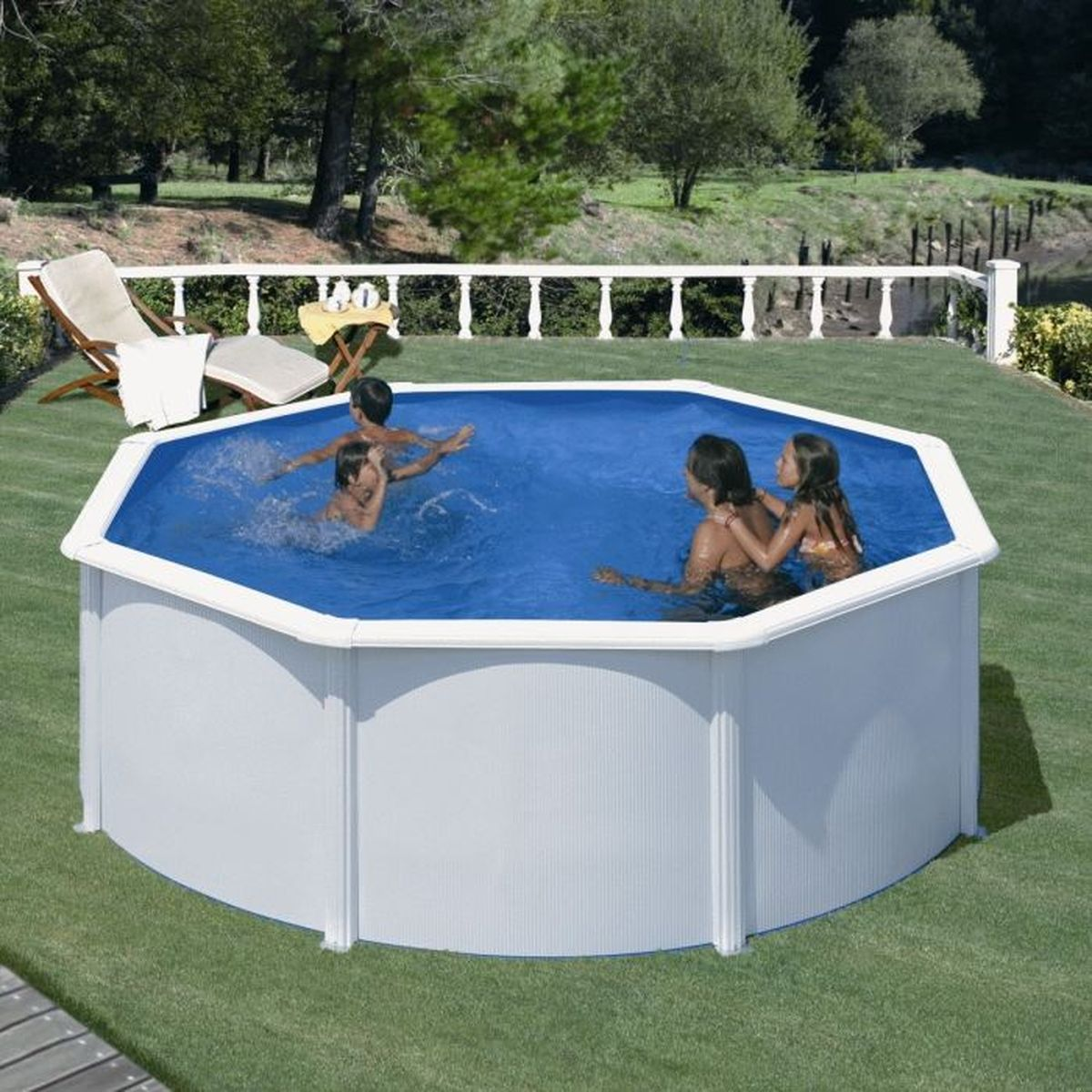 Personas nadando en una piscina octogonal. Césped verde rodea la piscina, con árboles y una valla blanca al fondo.