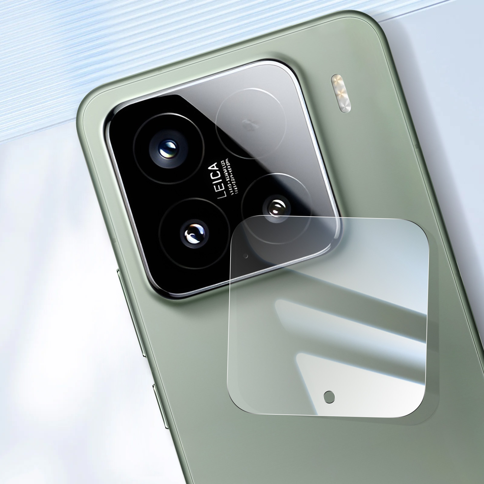 Primo piano del modulo fotocamera di un telefono verde con obiettivi Leica e protezione schermo. Sfondo sfocato bianco e blu.