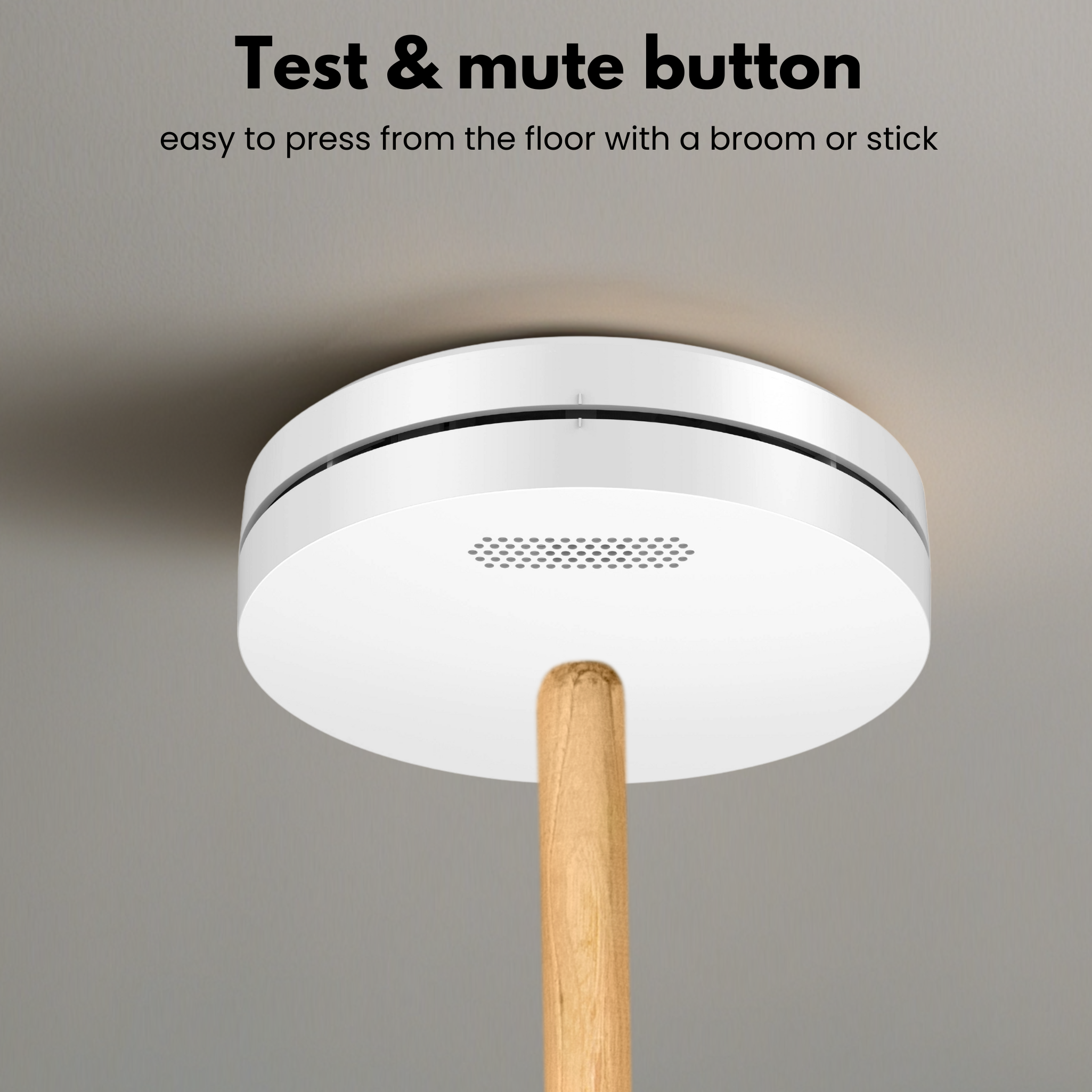 Ein weißer Rauchmelder auf grauem Hintergrund. Ein Holzstab berührt den Melder. Text oben: 'Test & Mute-Taste'.