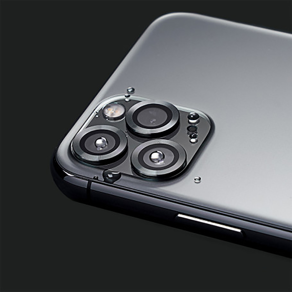 Close-up van de achterkant van een smartphone met camera. Drie grote lenzen, kleine flitser en waterdruppels zichtbaar.