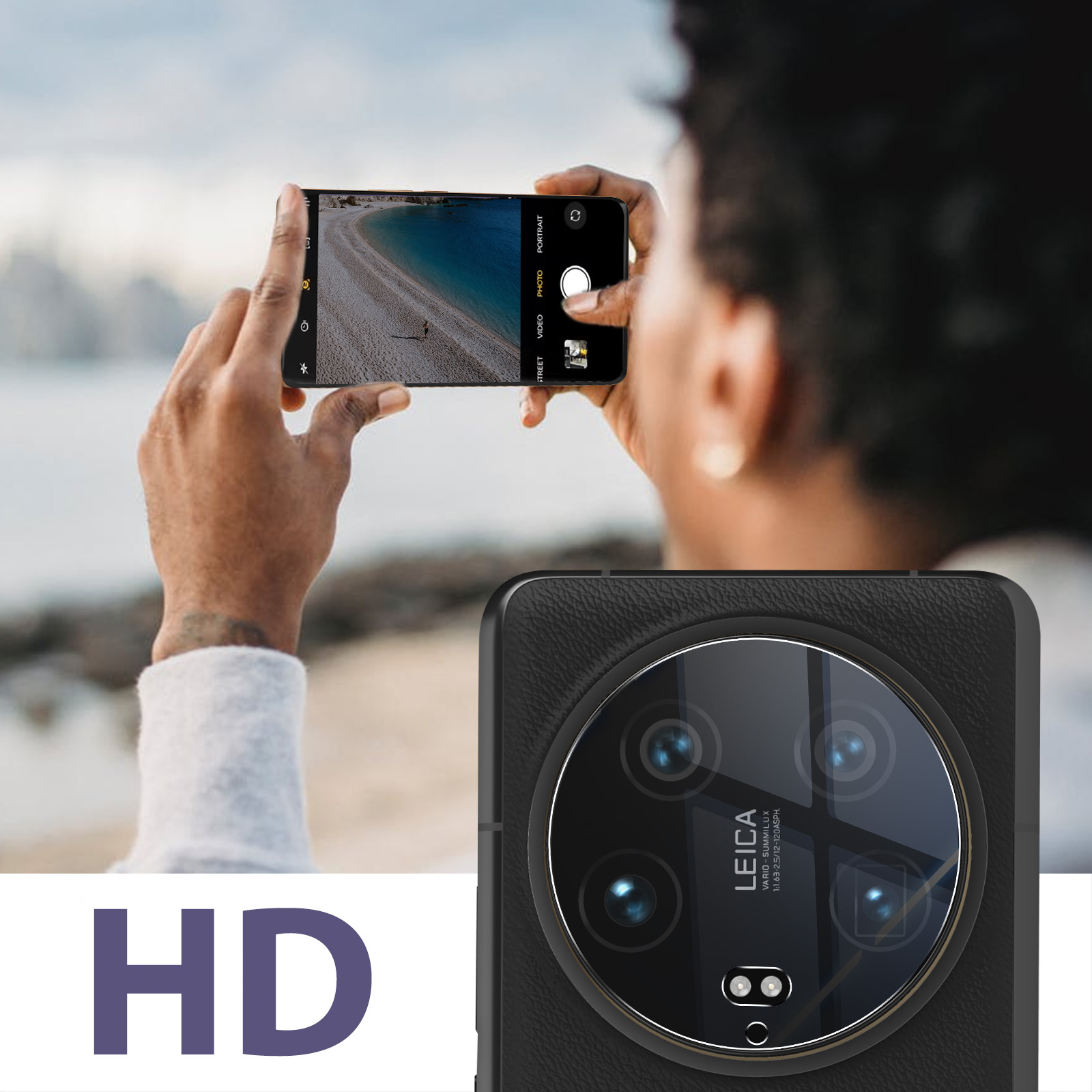Una persona tiene in mano uno smartphone, mostrando una scena di spiaggia. Il telefono ha una fotocamera con una grande lente e il logo Leica.