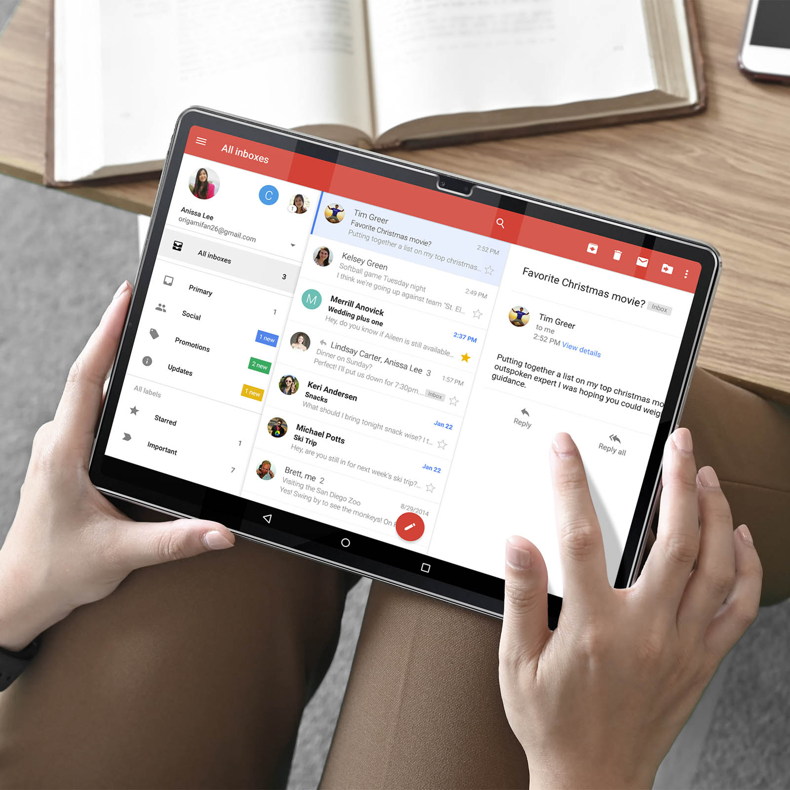 Un tablet visualizza una casella di posta elettronica. Una mano tocca lo schermo. Le email sono visibili.