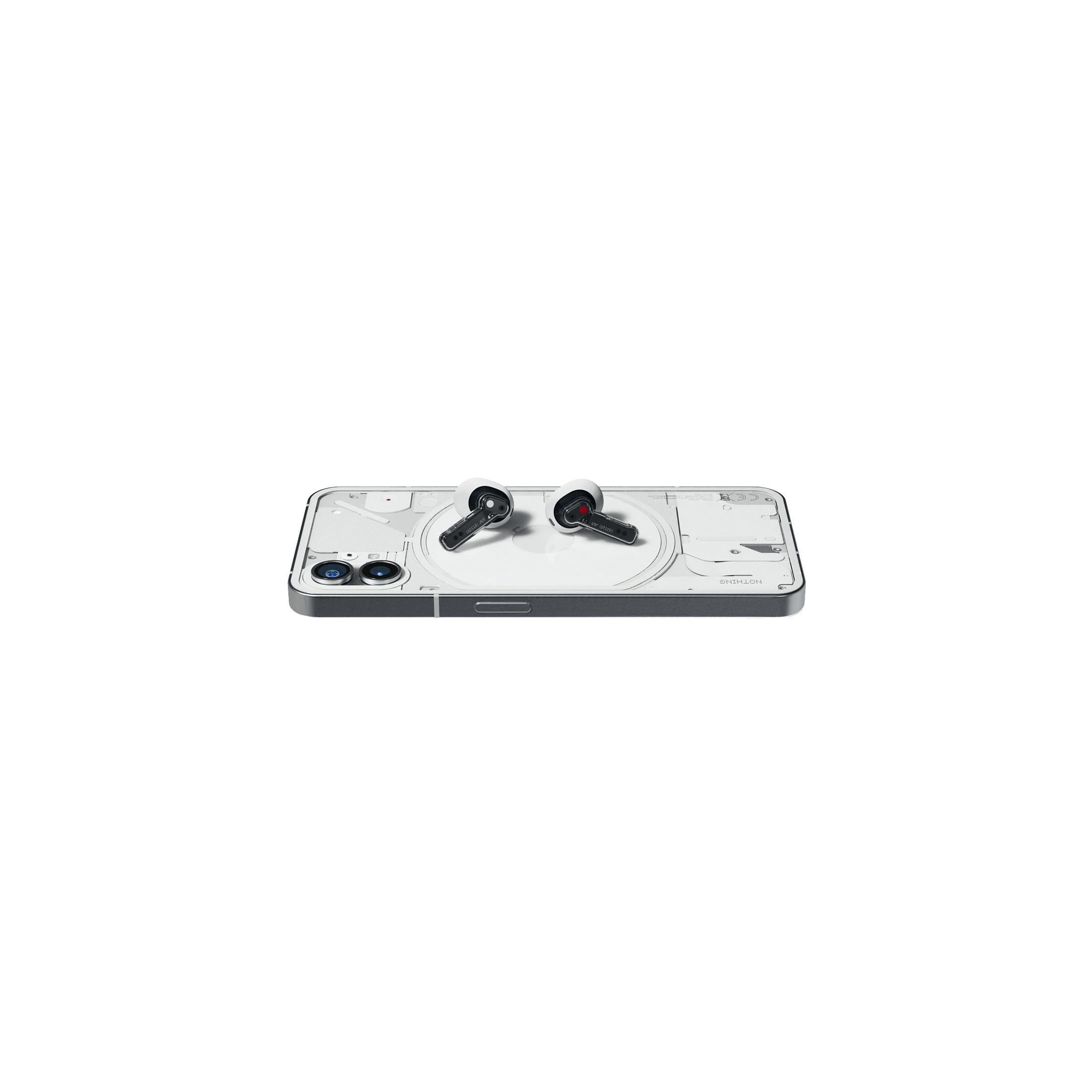 Un smartphone con auriculares en una superficie blanca. El teléfono es plateado con la parte trasera transparente. Los auriculares son negros y blancos.