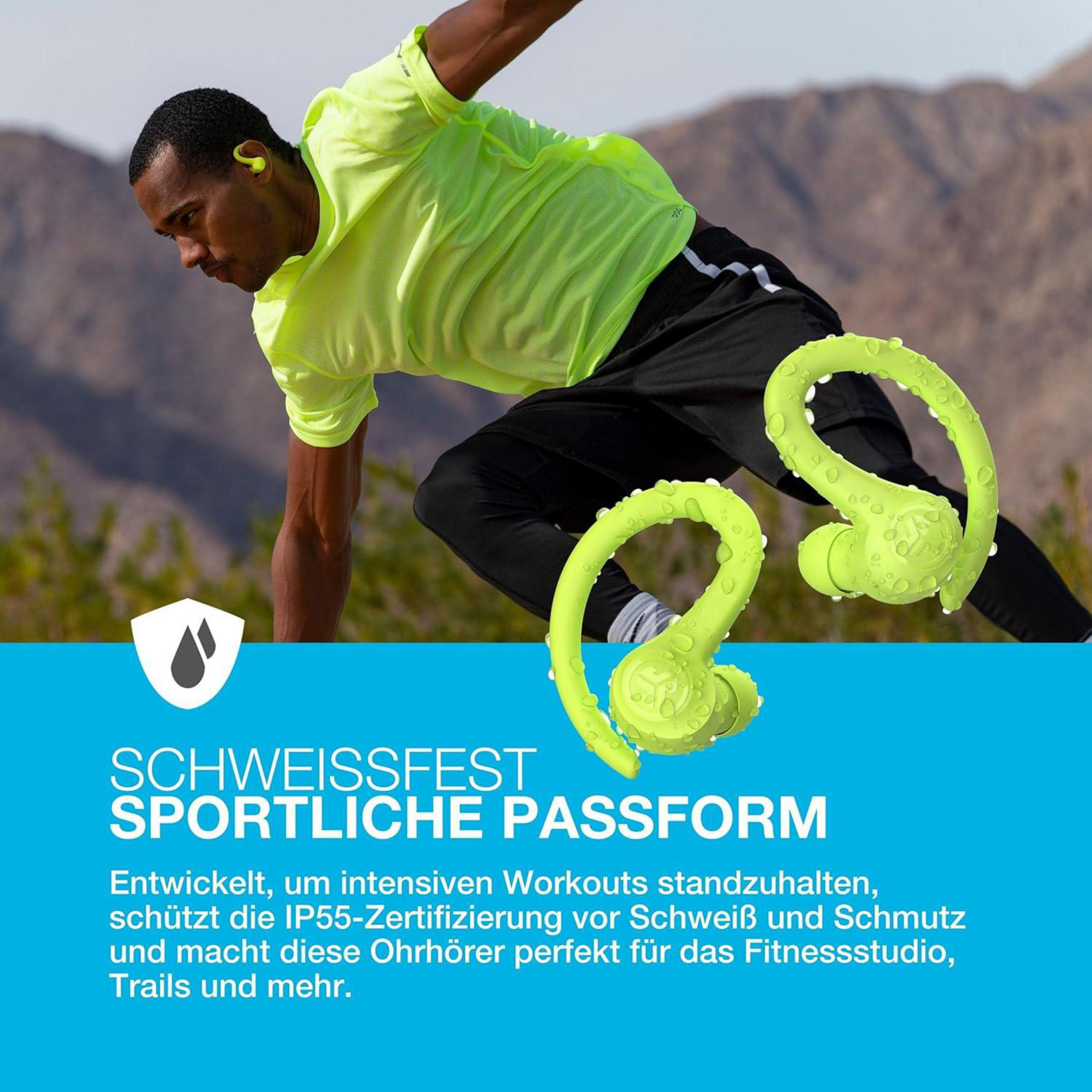 Mężczyzna w neonowo zielonych ubraniach do ćwiczeń ćwiczy. Pokazano dwie neonowo zielone bezprzewodowe słuchawki. Tłem jest góra.