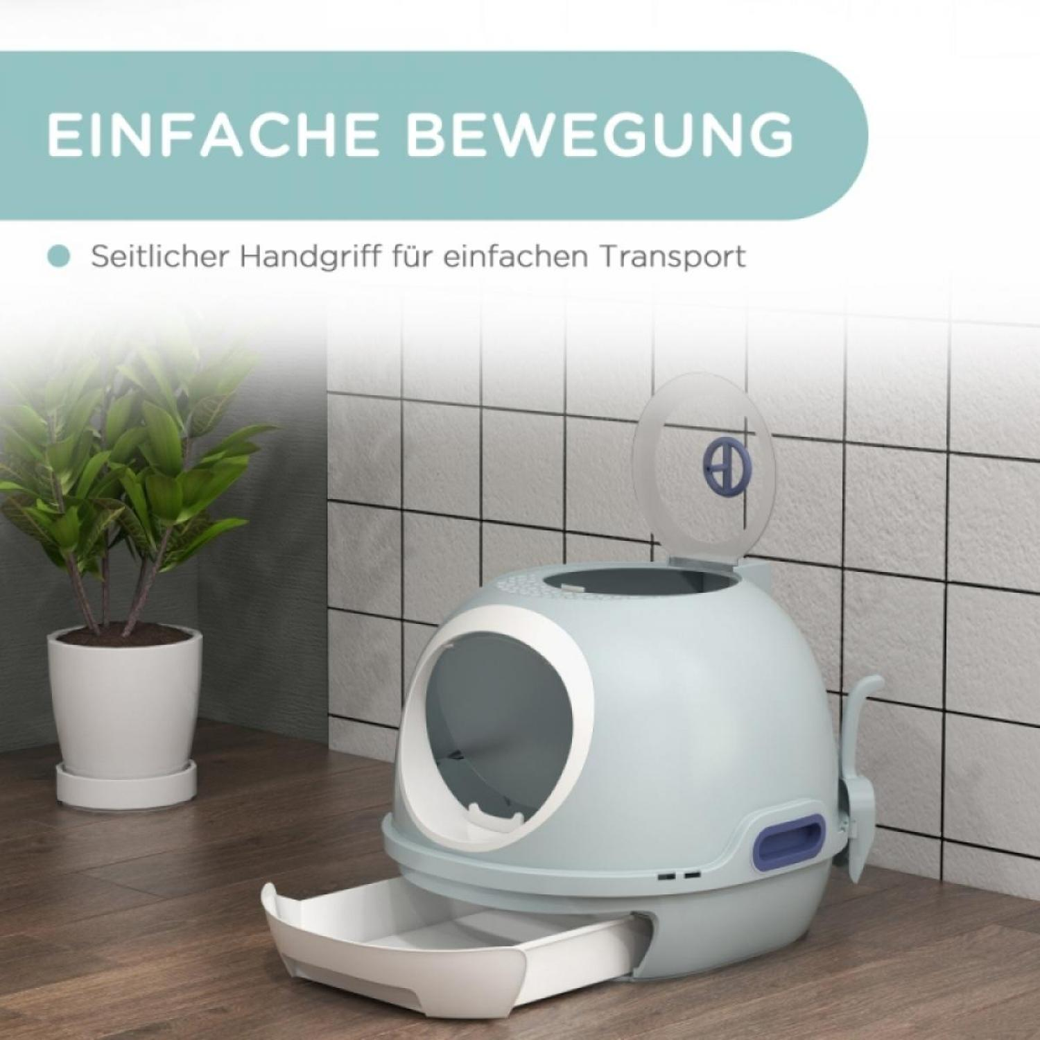 Eine hellblaue Katzentoilette mit Griff und Schaufel. Links steht eine Pflanze in einem weißen Topf.