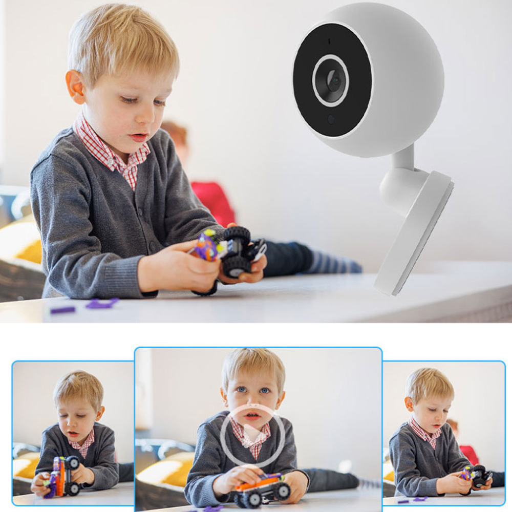 Ein kleiner Junge spielt mit Spielzeugautos, im Hintergrund ist eine Überwachungskamera. Der Junge trägt einen grauen Pullover und ein rot-weißes Hemd.