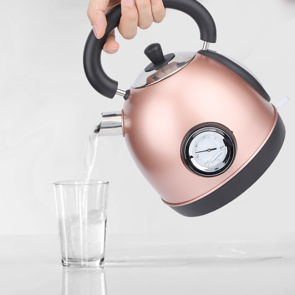 Eine Hand gießt Wasser aus einem roségoldenen Wasserkocher in ein Glas. Der Wasserkocher hat ein Thermometer. Klares Wasser wird gegossen.
