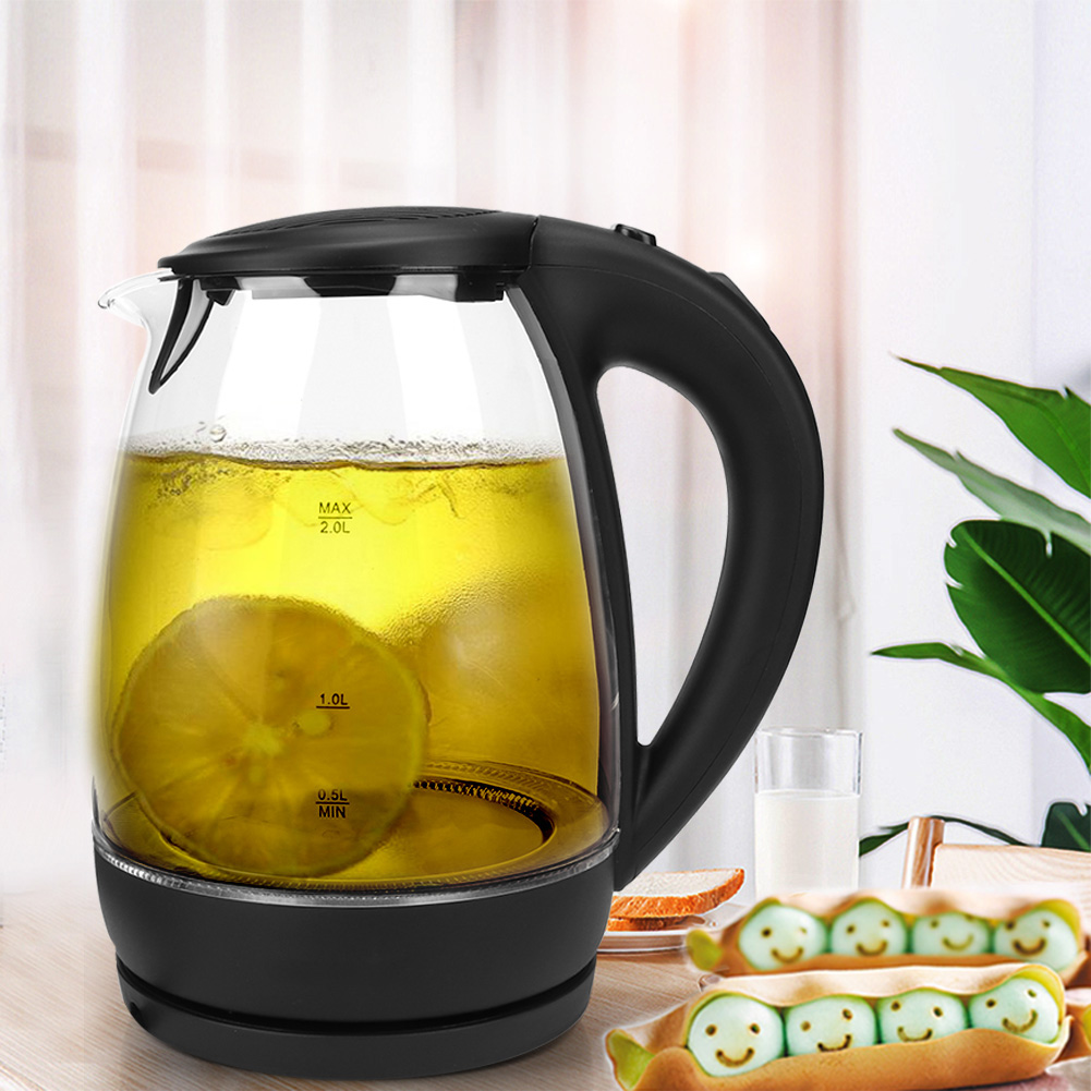 Ein Glaskessel mit Zitronenscheiben steht auf einem Tisch. Ein Glas Milch und ein Tablett mit Eiern mit Smiley-Gesichtern sind ebenfalls vorhanden.