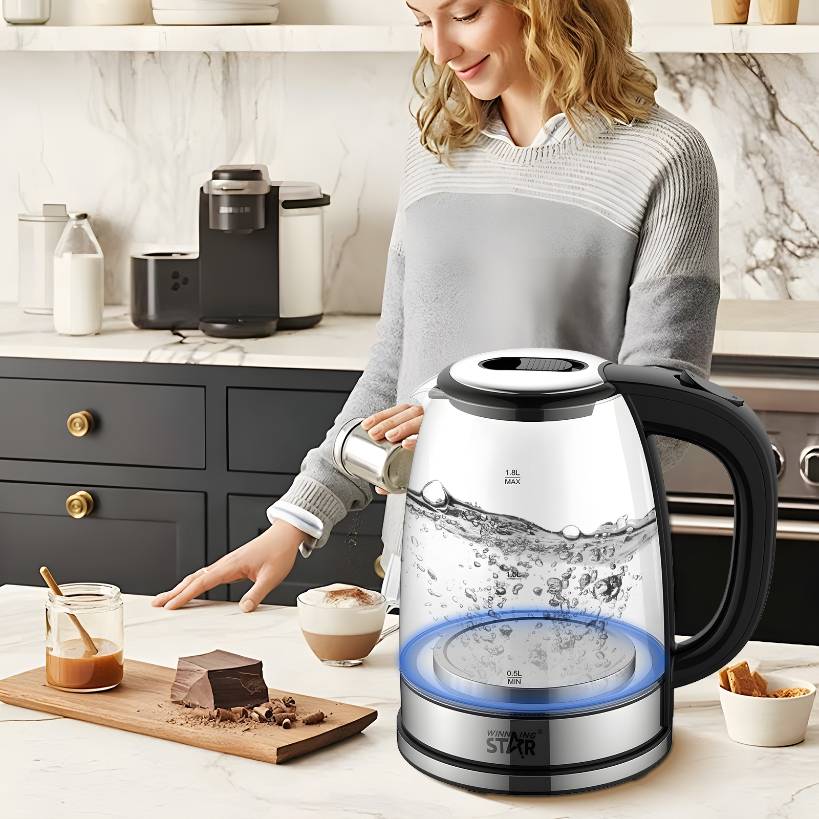 Eine Frau gießt Wasser in einen Glaskessel. Ein Holzbrett hält Schokolade und Karamell. Im Hintergrund steht eine Kaffeemaschine.