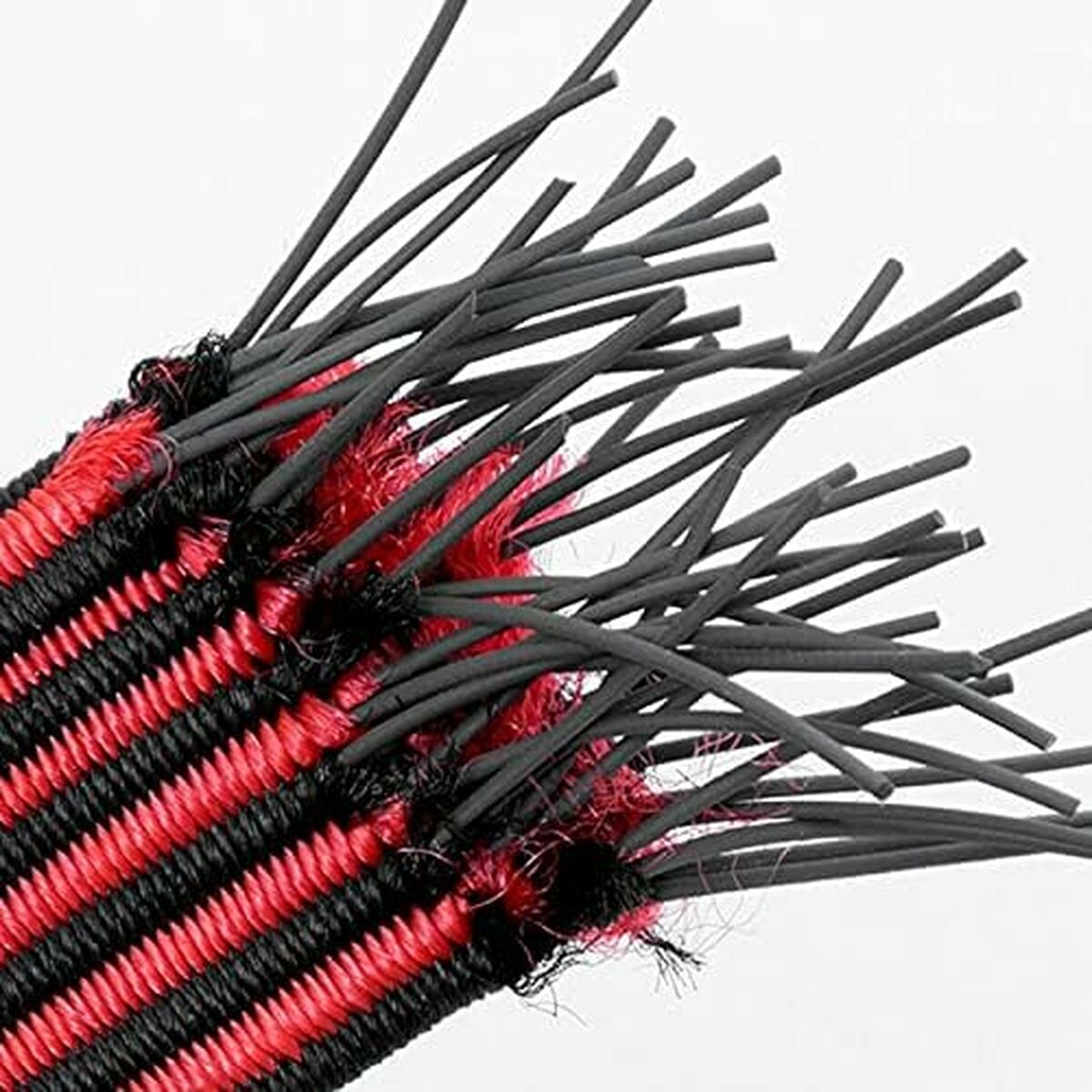 Nahaufnahme eines gewebten Materials mit schwarz-roten Streifen. Schwarze, dünne, stangenartige Strukturen erstrecken sich nach außen.