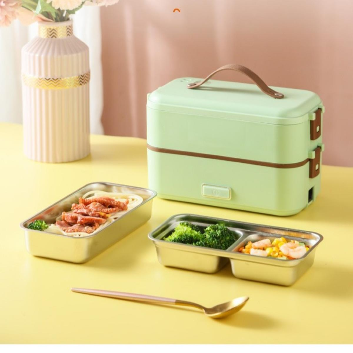 Eine grüne Lunchbox mit braunem Griff, zwei Lebensmittelbehälter mit Essen, eine Vase mit Blumen und ein Löffel auf gelbem Untergrund.