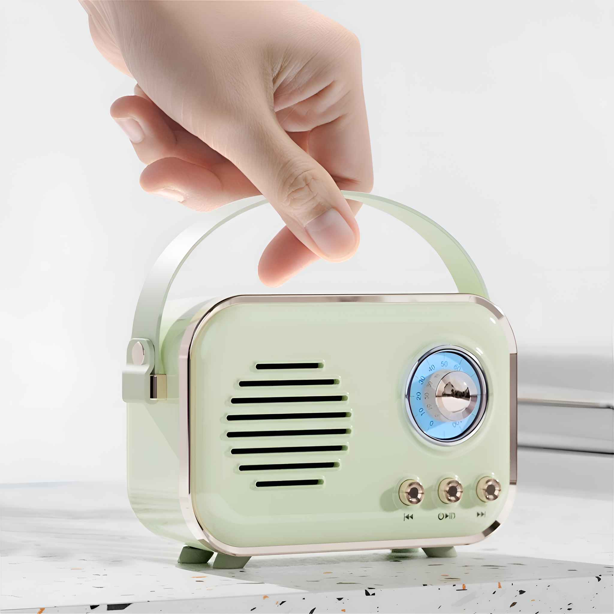 Eine Hand hält ein mintgrünes Retro-Radio. Das Radio hat einen Griff, einen Lautsprecher und Knöpfe. Es steht auf einer weißen Oberfläche.