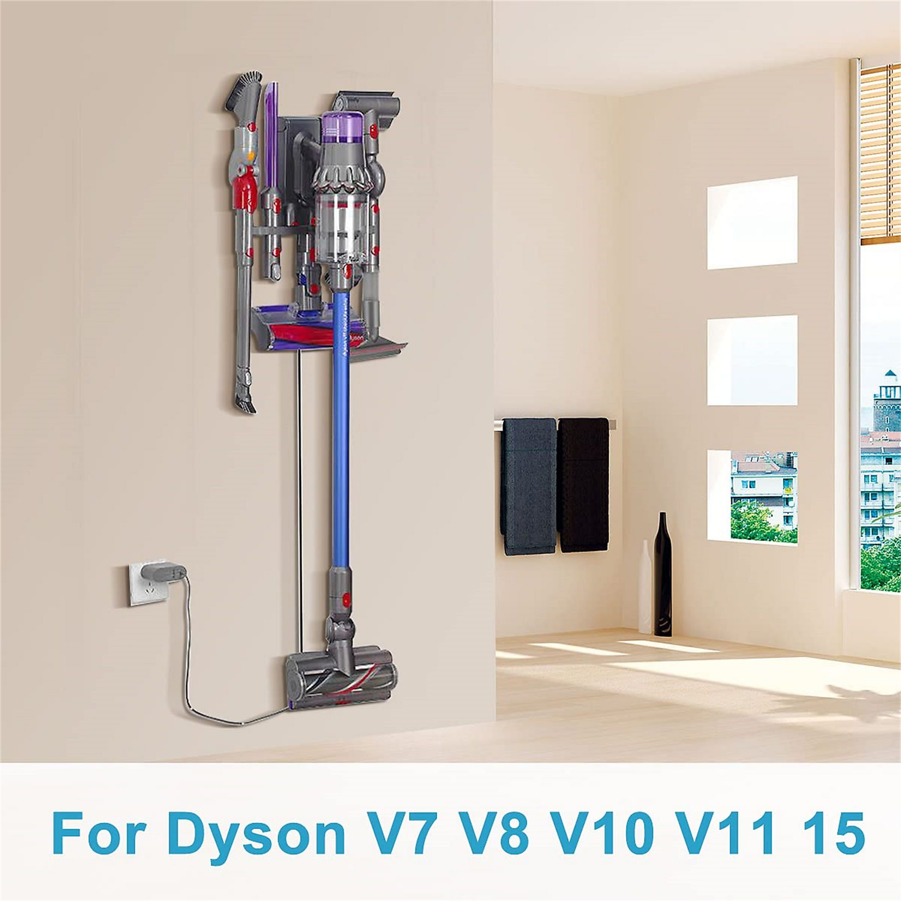 Ein Dyson-Staubsauger an der Wand. Er ist blau und grau. Im Hintergrund sind zwei Handtücher und eine Vase.