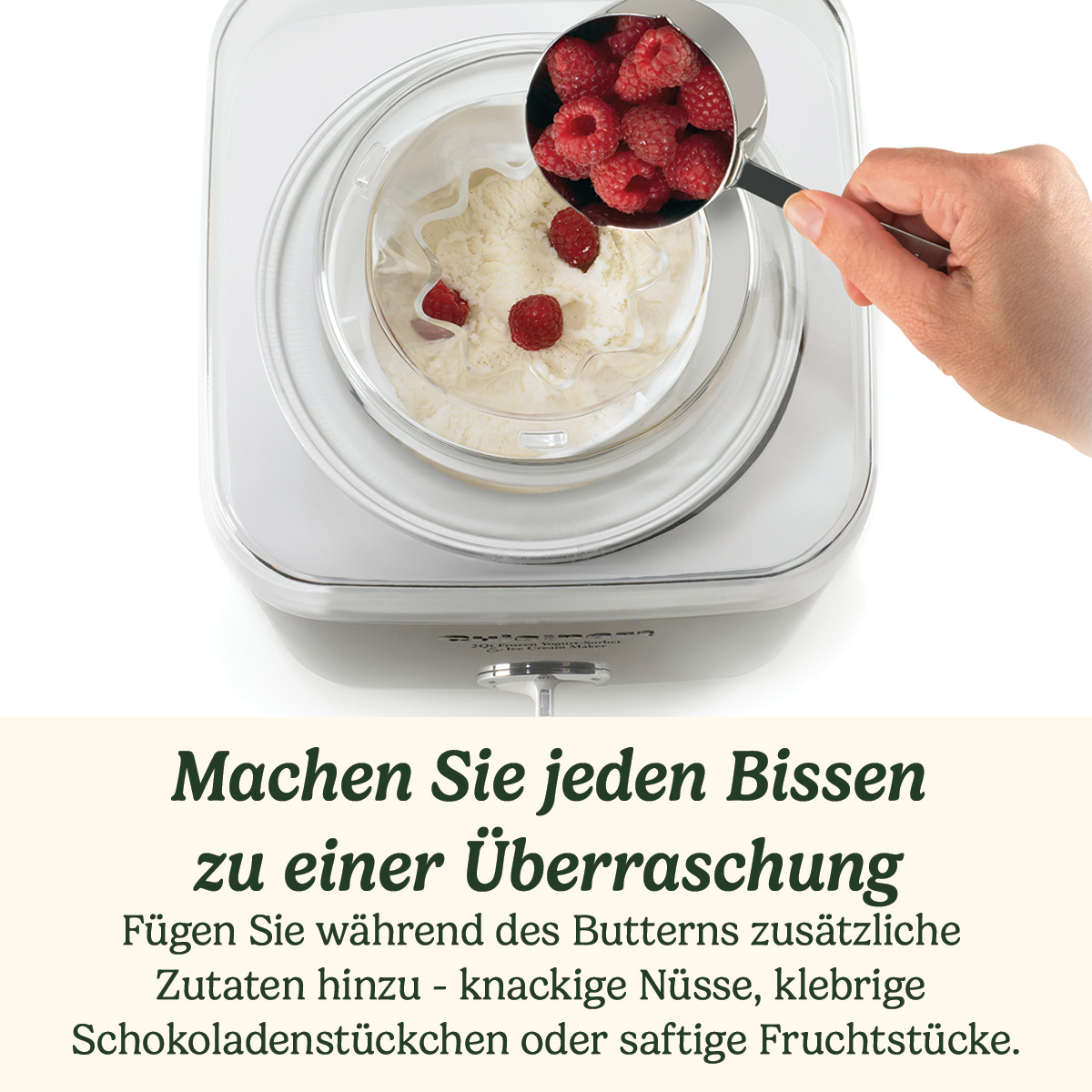 Eine Hand gibt Himbeeren in eine Eismaschine. Die Maschine ist weiß und hat eine klare Schüssel. Text unten: 'Machen Sie jeden Bissen zu einer Überraschung'.
