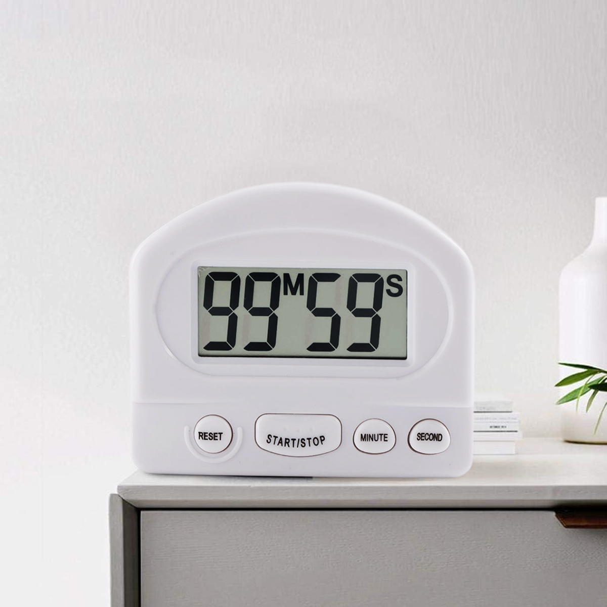 Ein weißer digitaler Küchentimer zeigt 99 Minuten und 59 Sekunden an. Tasten für Reset, Start/Stopp, Minute und Sekunde sind sichtbar.