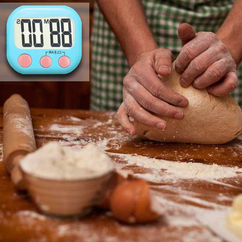 Hände kneten Teig auf einer Holzoberfläche mit Mehl, einer Teigrolle, einer Schüssel mit Mehl und einem digitalen Timer. Eine Eierschale ist ebenfalls vorhanden.