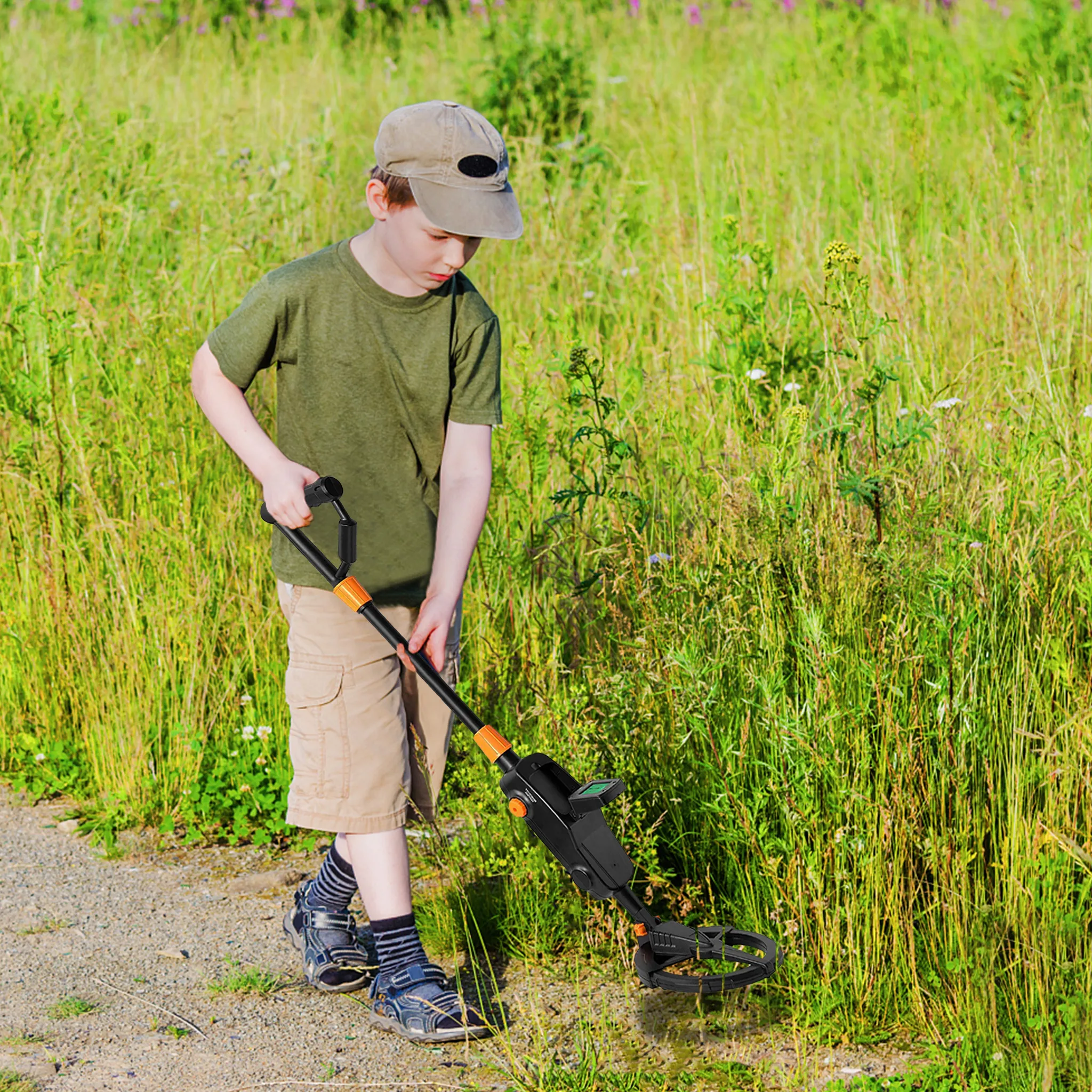 Ein Junge mit Mütze benutzt einen Metalldetektor in einem Feld. Der Detektor ist schwarz und orange. Hohes Gras umgibt ihn.