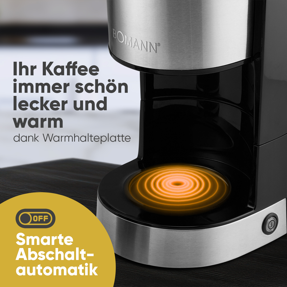 Ein schwarzer und silberner Kaffeeautomat mit einer orangefarben leuchtenden Warmhalteplatte. Text auf Deutsch.