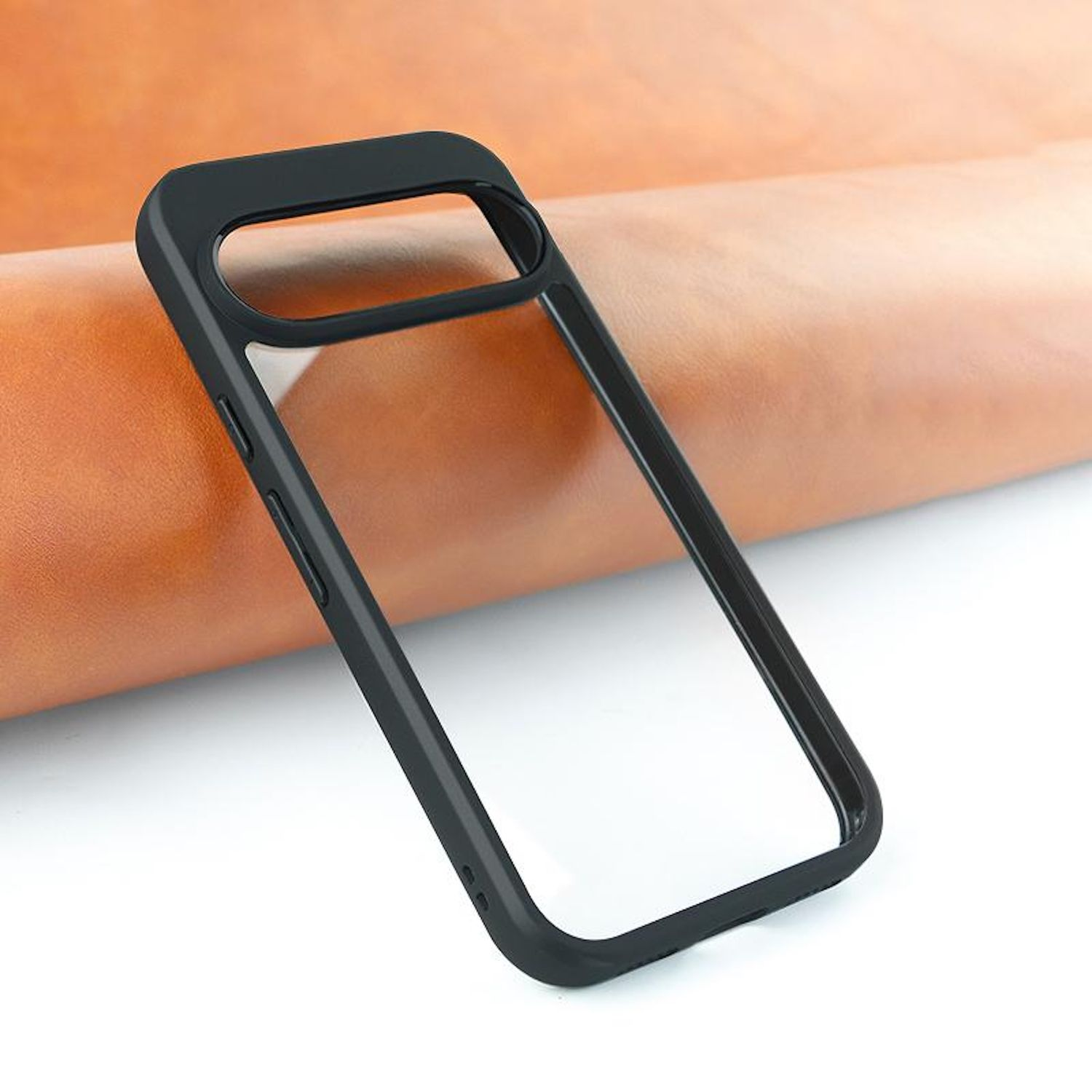 Una funda negra para teléfono descansa sobre una superficie de cuero marrón. La funda está vacía y tiene un centro transparente. El fondo es claro.