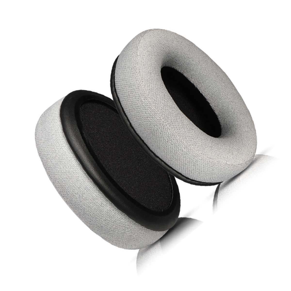 Due cuscinetti auricolari per cuffie grigi e neri su sfondo bianco. I cuscinetti sono di forma ovale.