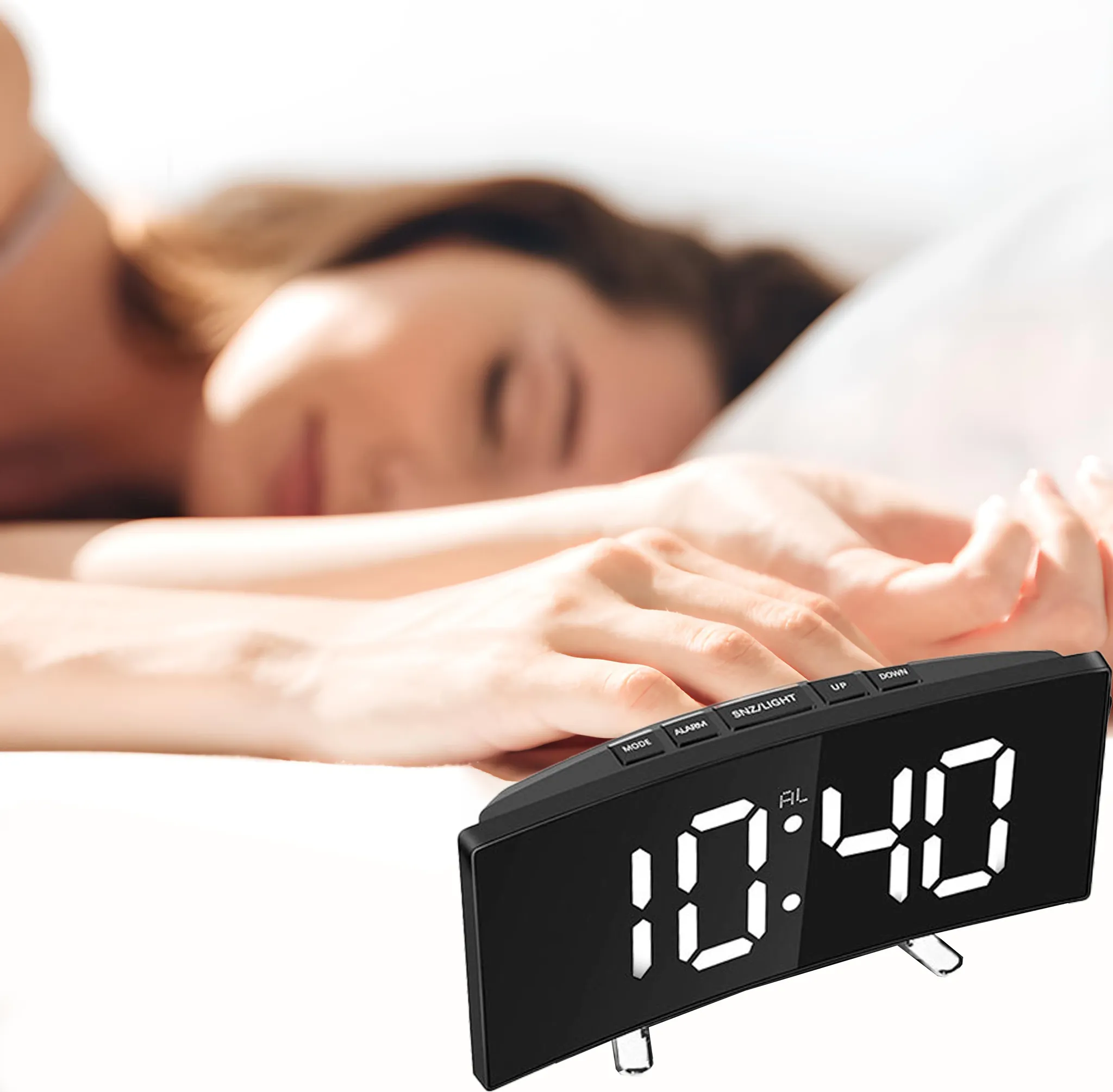 Eine Frau schläft im Bett mit einer Digitaluhr, die 10:40 Uhr anzeigt. Schwarze Uhr mit weißen Ziffern im Vordergrund.