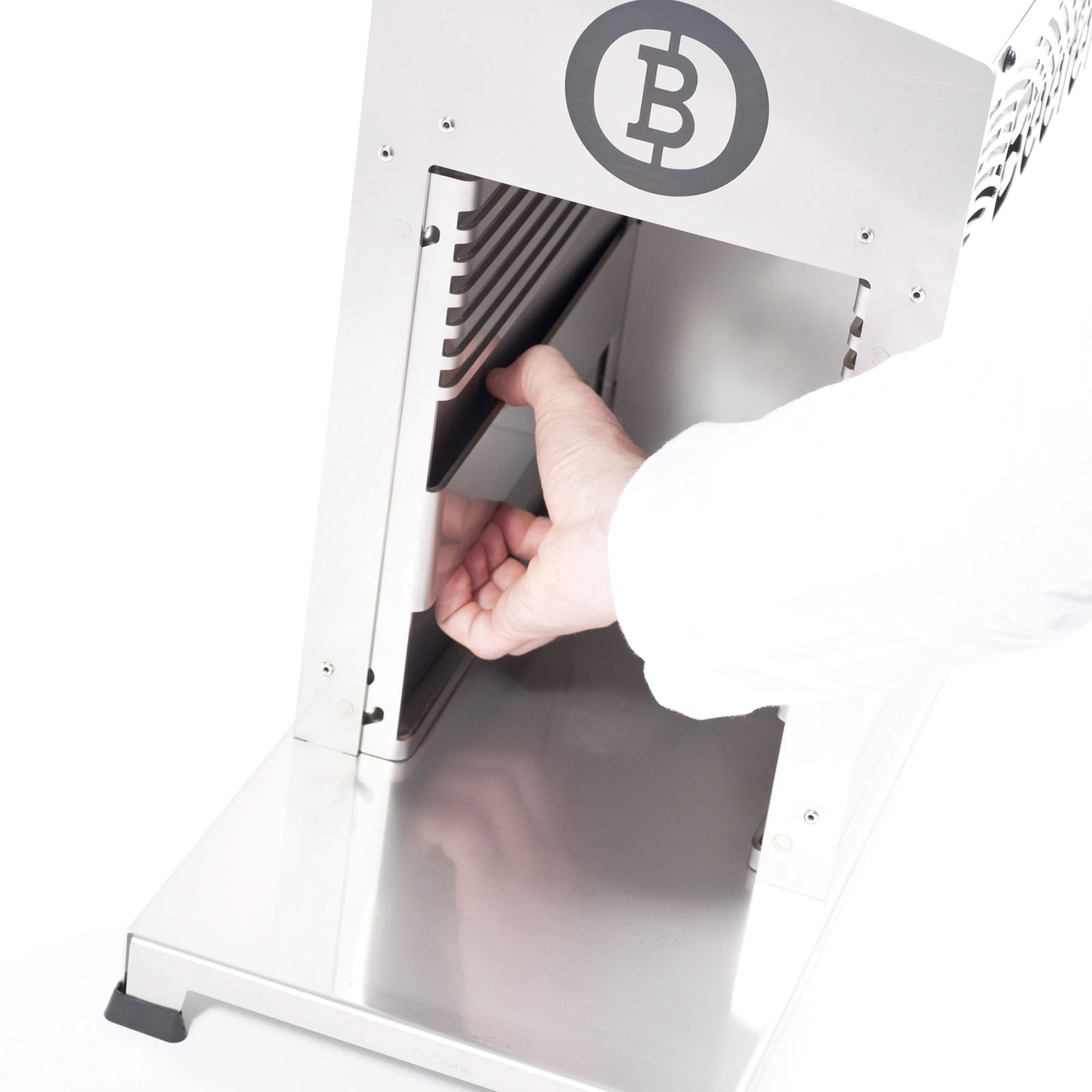 Eine Hand in einem weißen Kittel führt ein schwarzes Objekt in eine silberne Maschine mit einem Bitcoin-Symbol ein.